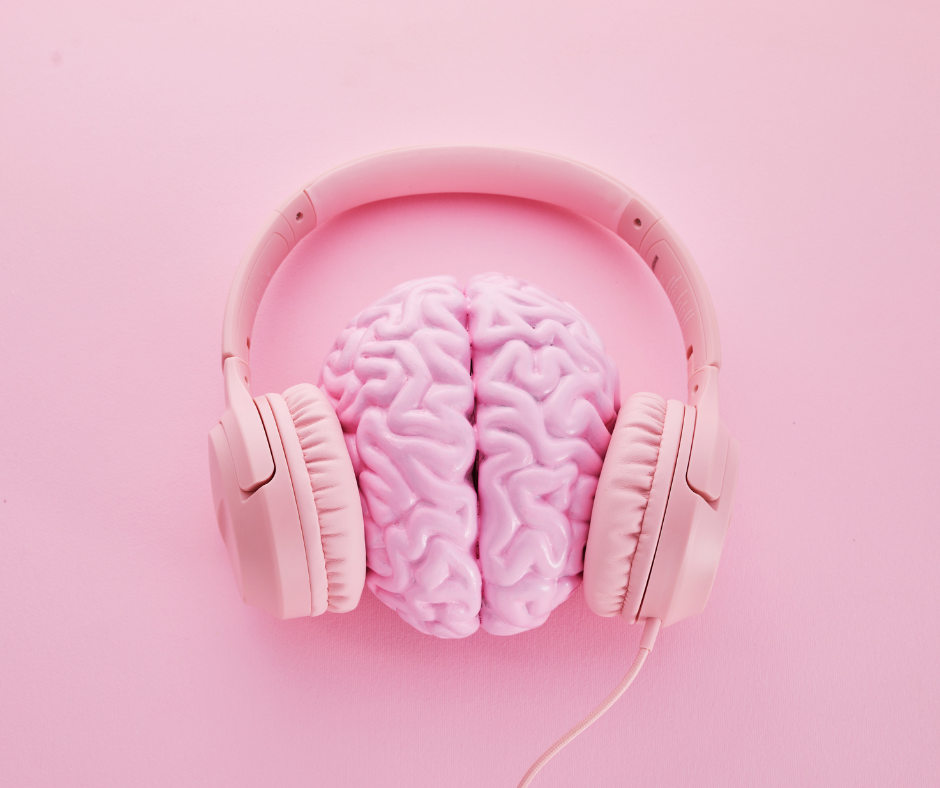 A stylized pink brain wearing pink headphones against a neutral background, symbolizing the connection between music, the brain, and cognitive processes.